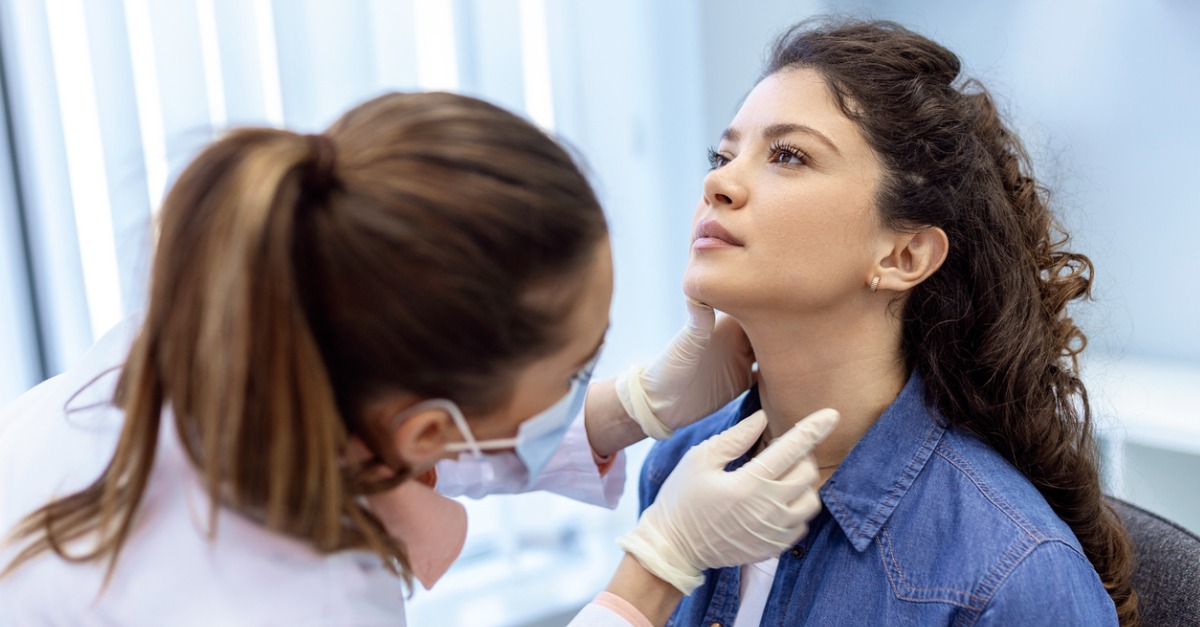 nurse checking patient's thyroid