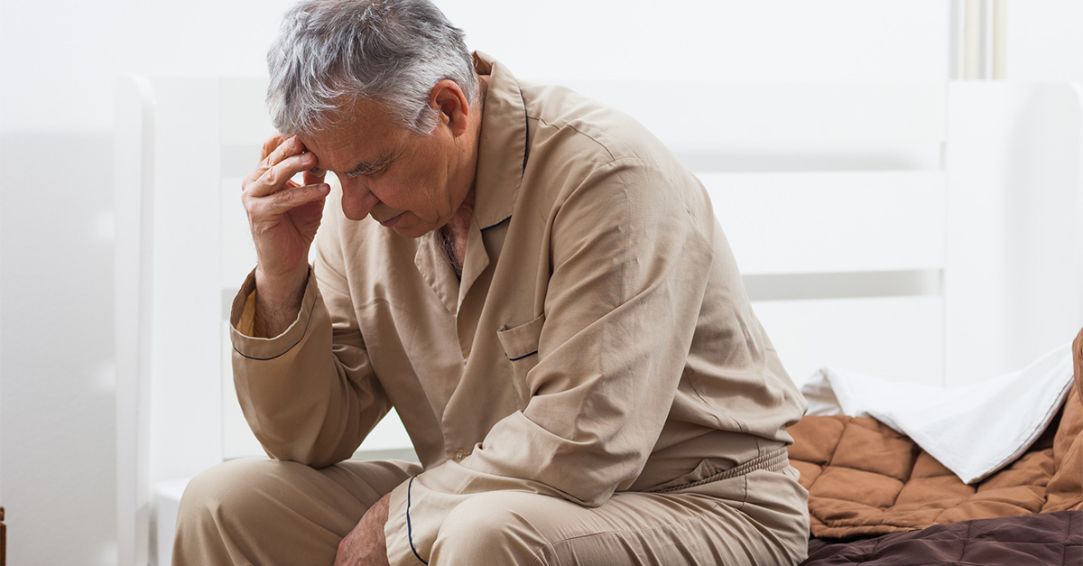 A senior man holding his head froma headache.